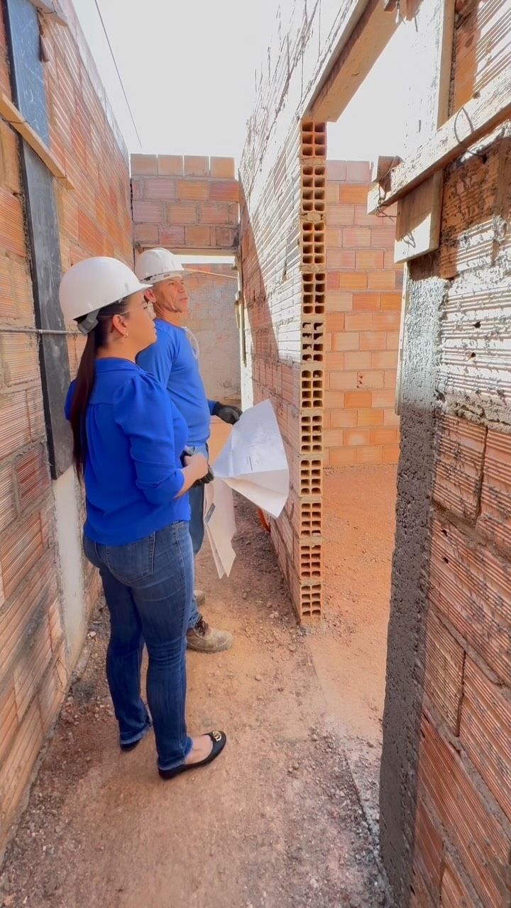 Thuany Ferreira conferindo a alvenaria de uma obra com o projeto em mãos